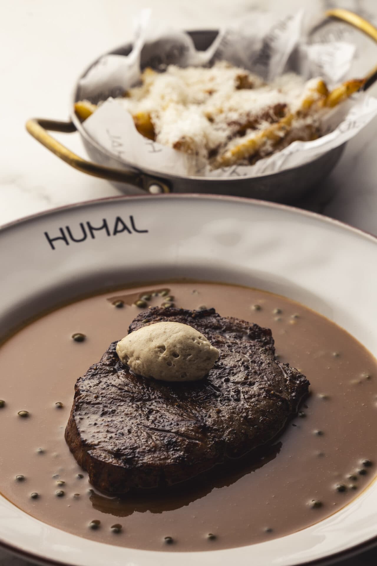 Steak au poivre HUMAL-logoga taldrikul